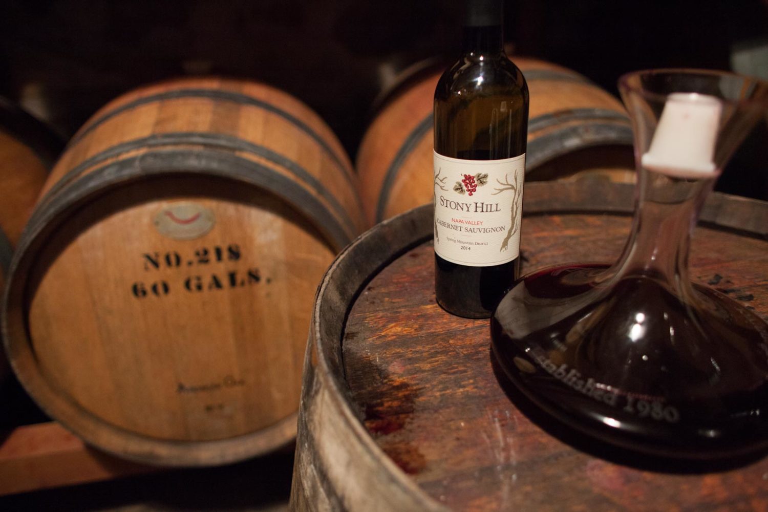 Amongst the barrels at Stony Hill Vineyards, with a bottle of 2014 Cabernet Sauvignon while the 2016 vintage ages beside it. ©Kevin Day / Opening a Bottle