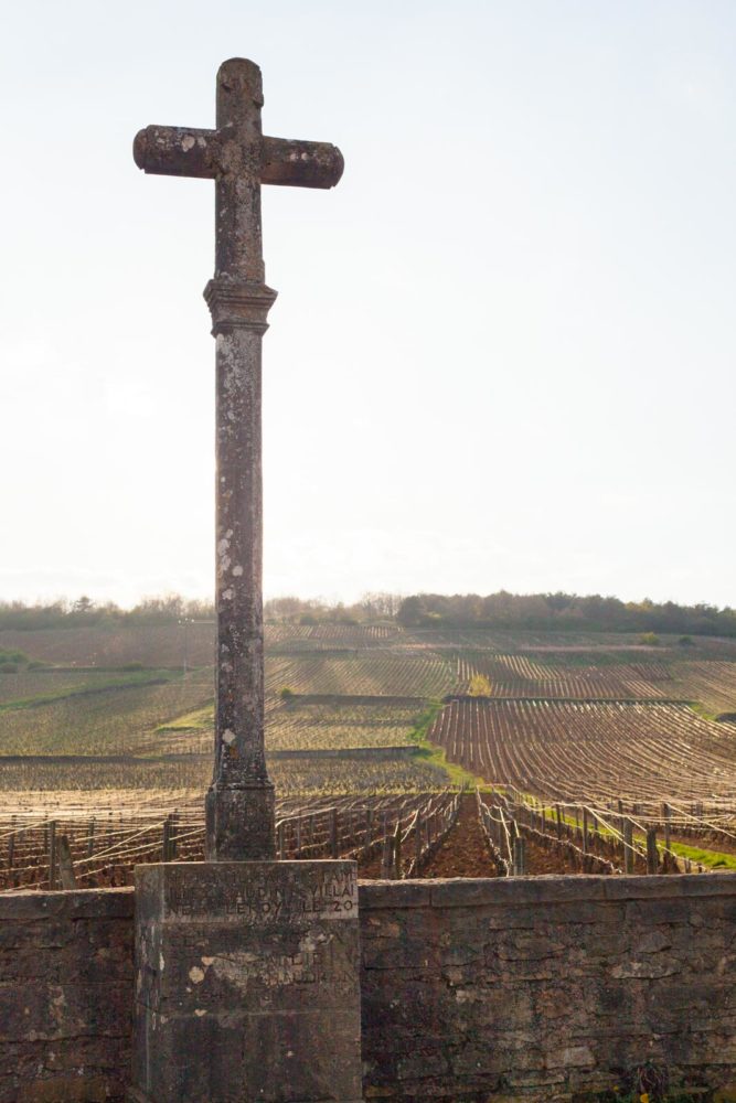 A simple cross marks the edge of the Romanée-Conti Grand Cru, just steps away from the domaine that shares its name. ©Kevin Day / Opening a Bottle