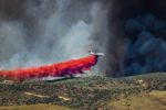 A plane drops fire retardant on a wildfire.