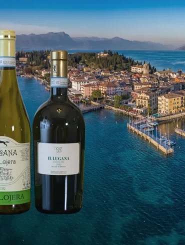 Three wine bottles from Lugana DOC in Italy with the picturesque village of Sirmione at dusk