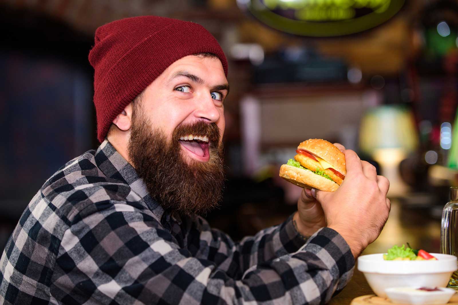 I couldn't write a better caption than the one provided by BigStockPhoto: "Hipster hungry man eat burger. Man with beard eat burger menu. Brutal hipster bearded man sit at bar counter. High calorie food. Cheat meal. Delicious burger concept. Enjoy taste of fresh burger"