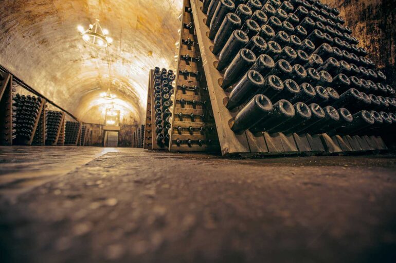 A Champagne Cellar with bottles in riddling racks.