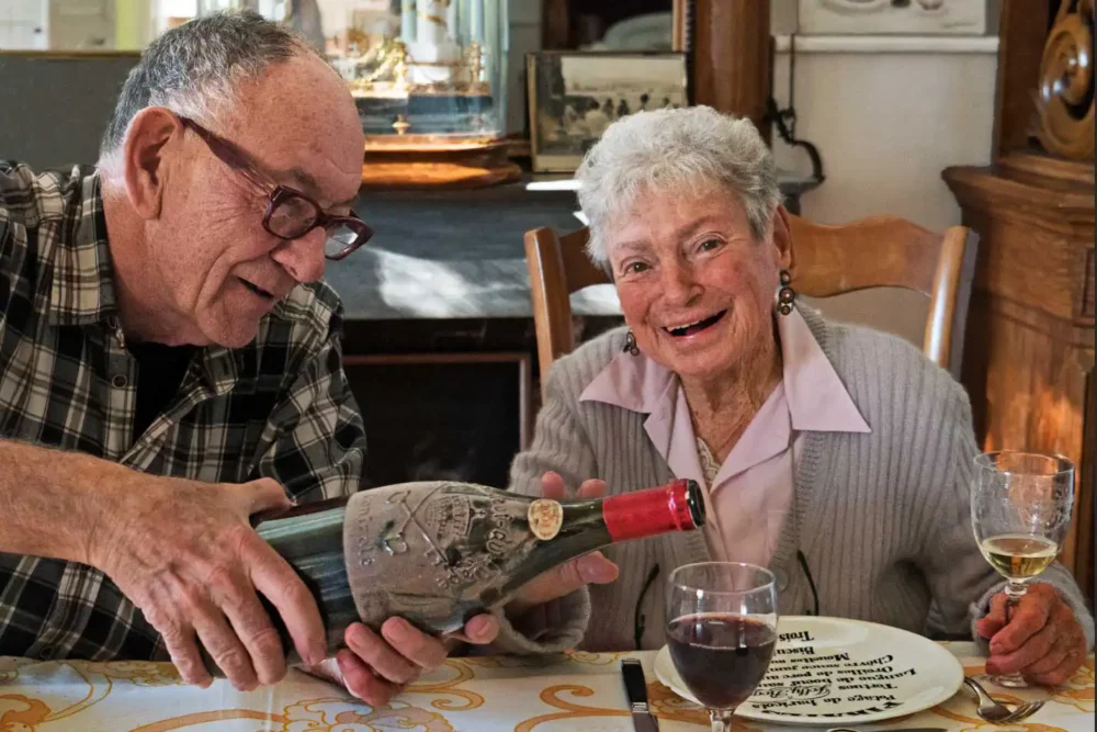 Kermit Lynch pours wine for Lulu Peyraud of Domaine Tempier.