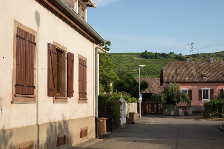 A village in Alsace with vineyards in the distance. ©Kevin Day/Opening a Bottle