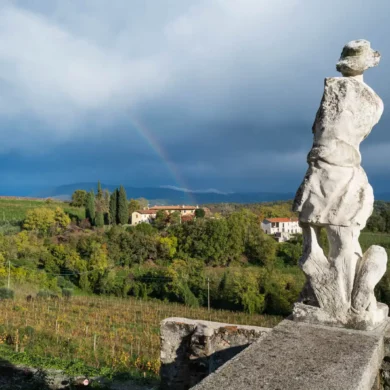 Rainbow and armless white marble statue at the Rosazzo Abbey in Friuli, Italy.