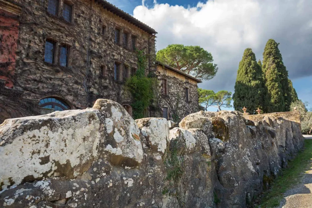 Biondi-Santi family home at Tenuta Greppo with an ancient stone wall.