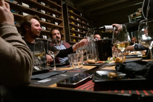 Friends enjoying white wine in a high-end restaurant in Friuli, Italy.