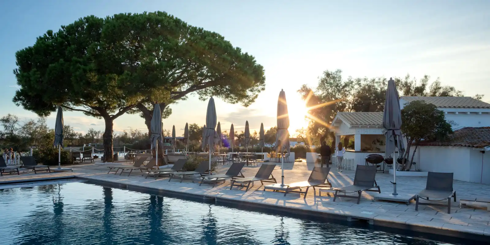 Sunset over the pool at the Camargue resort Mas de la Fouque in Provence, France.