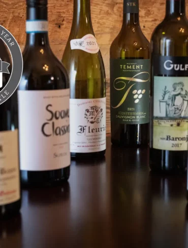 Opening a Bottle's Top 12 Wines of 2023: six wine bottles on a wood table