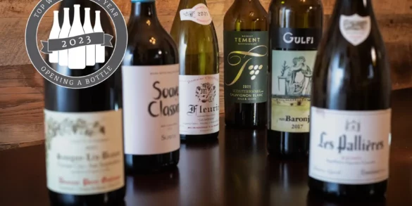 Opening a Bottle's Top 12 Wines of 2023: six wine bottles on a wood table