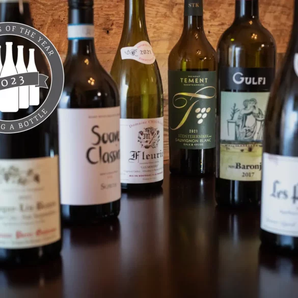 Opening a Bottle's Top 12 Wines of 2023: six wine bottles on a wood table