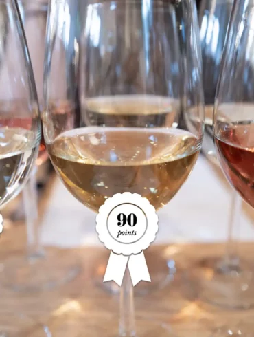 Three wine glasses with awards slapped on them