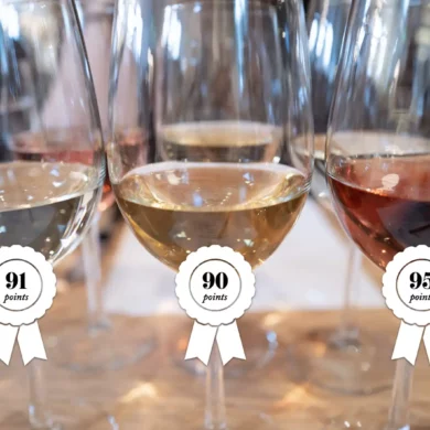 Three wine glasses with awards slapped on them