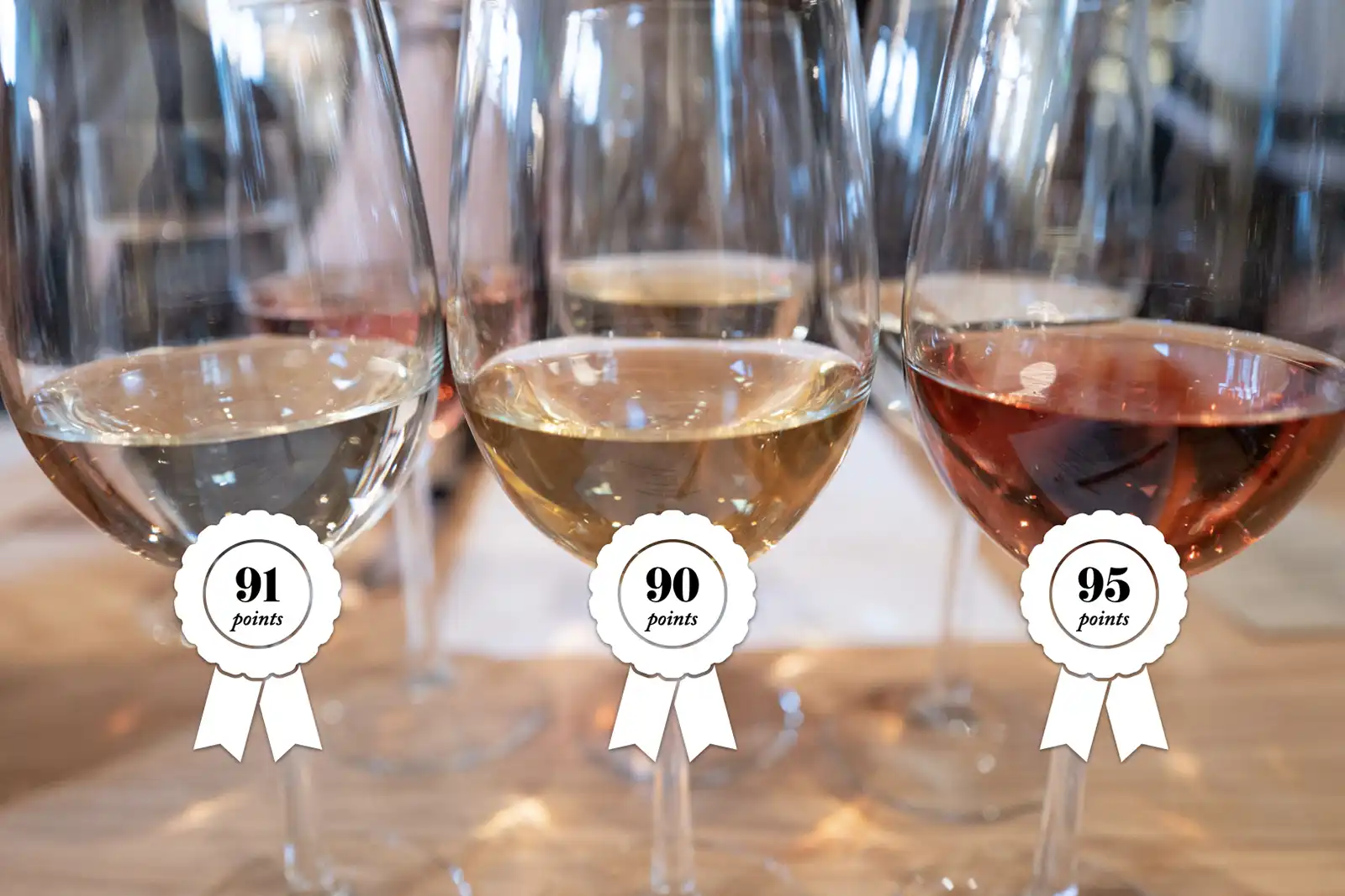 Three wine glasses with awards slapped on them