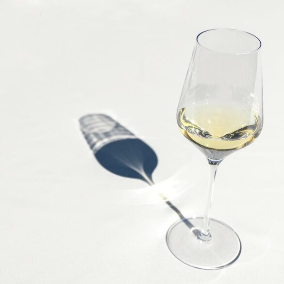 white wine in a wine glass on a white background with shadow
