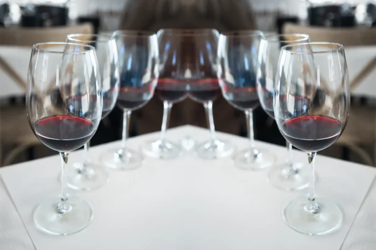 Mirror image of red wine glasses.