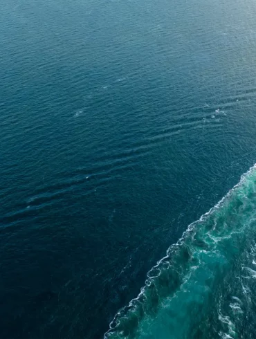 Container ship heading off screen at sea