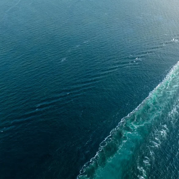 Container ship heading off screen at sea