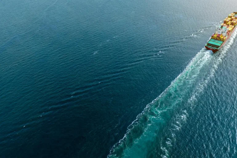 Container ship heading off screen at sea
