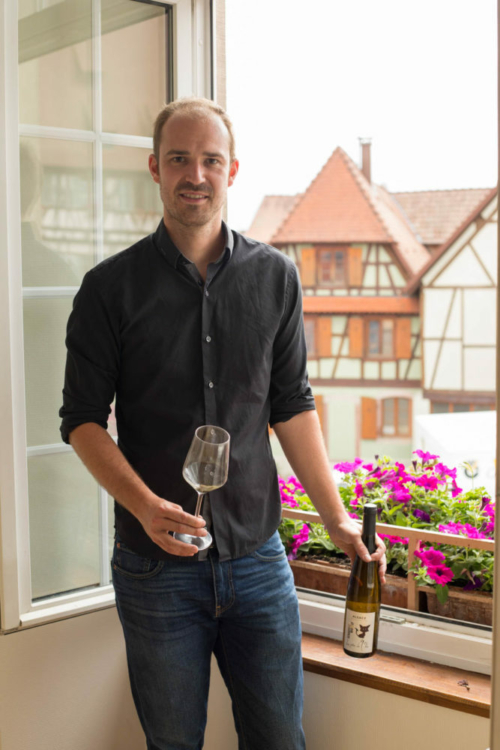 Maxime Woerly of Domaine Schaeffer Woerly, with his family winery behind him out the window. ©Kevin Day/Opening a Bottle