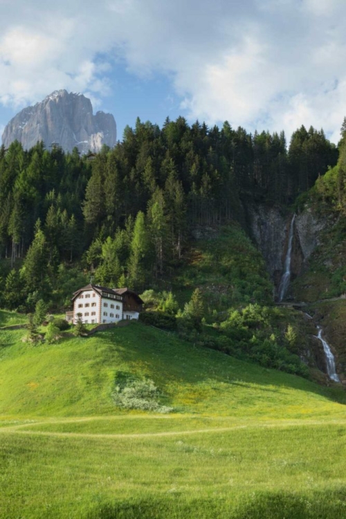 A waterfall and Sassolongo/Langkofel rising in the distance near Santa Cristina di Valgardena/St. Christina in Gröden. ©Kevin Day/Opening a Bottle